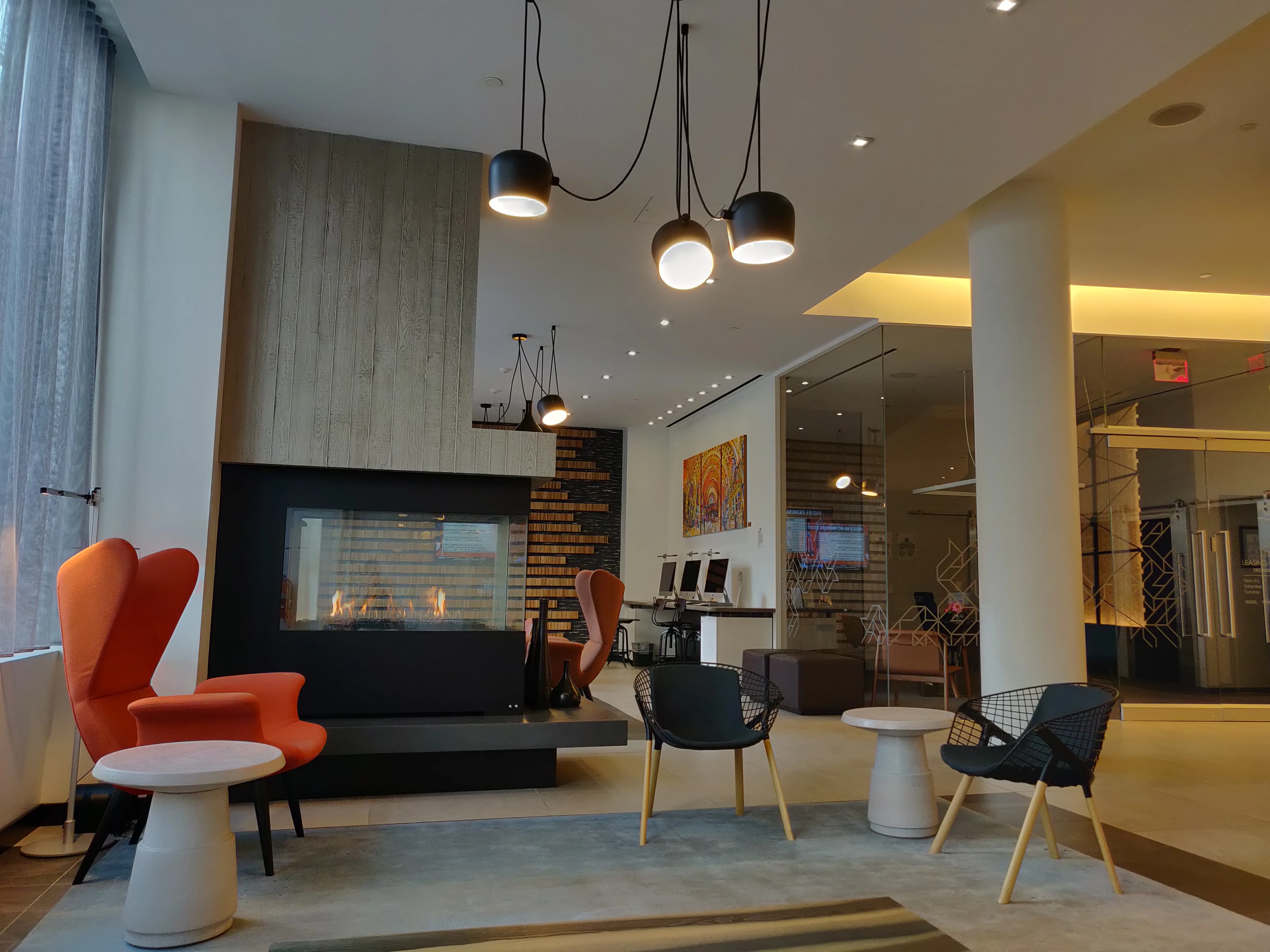 Lobby of a contemporary apartment building with lounge seating and a doorman desk