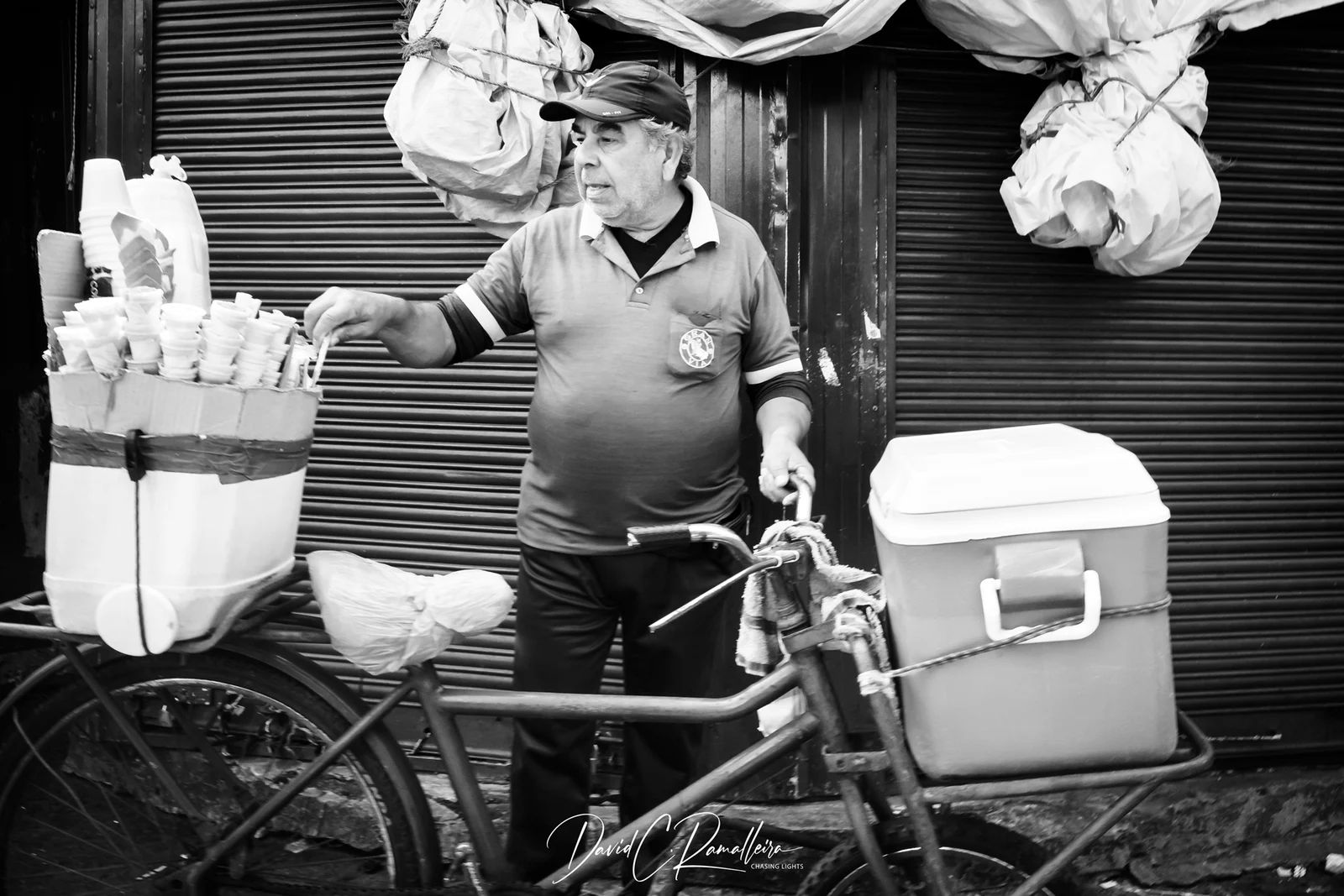 A vendor beside a bicycle loaded with insulated containers and cups at Mercado 4 in Asunción.