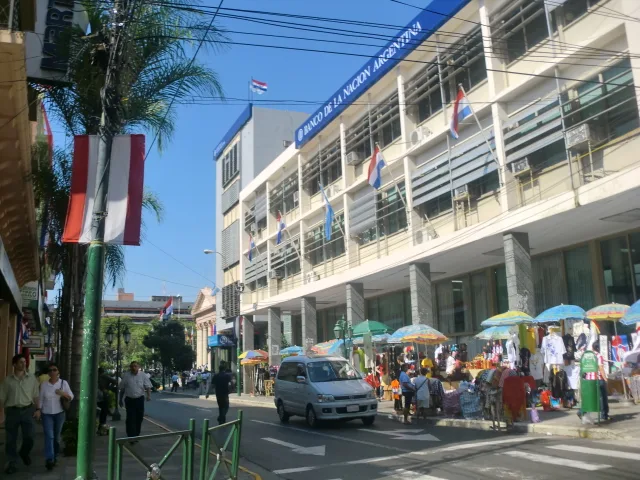 Calle Palma in Asunción's historic center, with ornate old facades, shop awnings and cars on a sunny day
