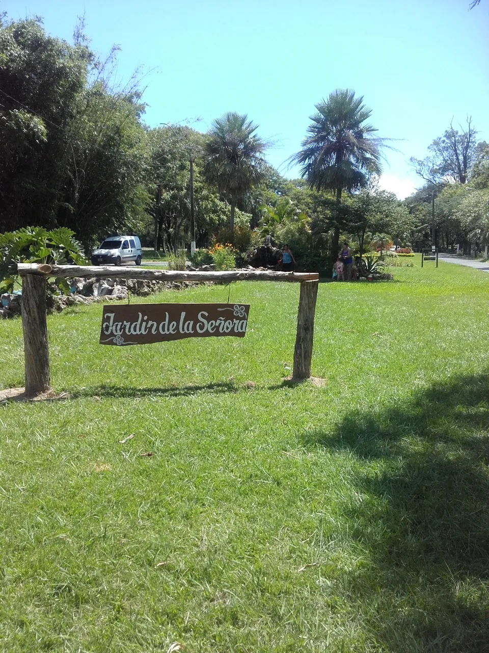 Jardín de la Señora sign beside grass, palms and a rock garden in the Jardín Botánico de Asunción