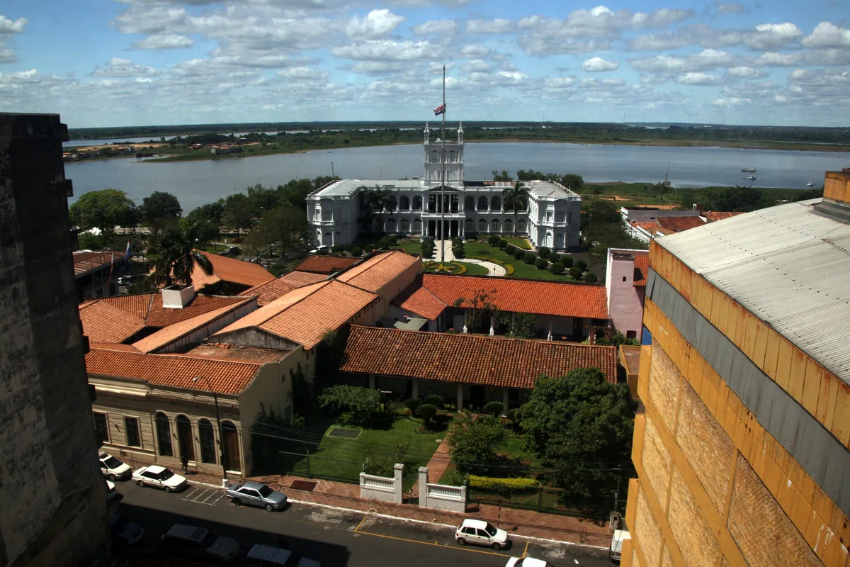 Vista elevada de archivo de los tejados de tejas rojas de la Manzana de la Rivera, con el Palacio de López y el río Paraguay al fondo