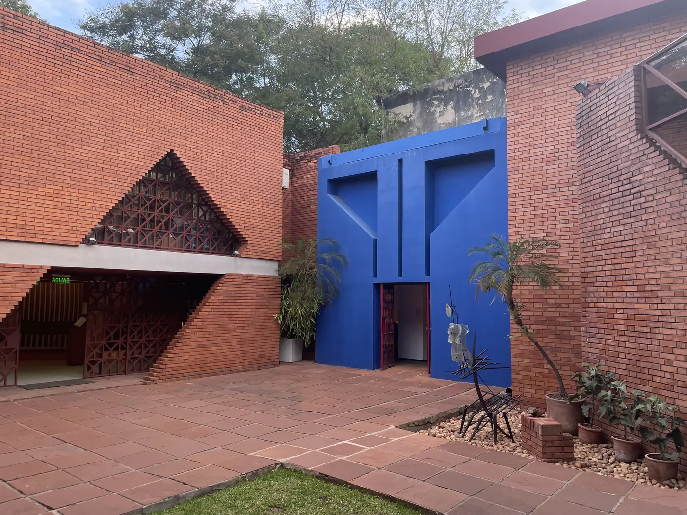 Red brick courtyard and bright blue entrance wall at the Museo del Barro, Asunción