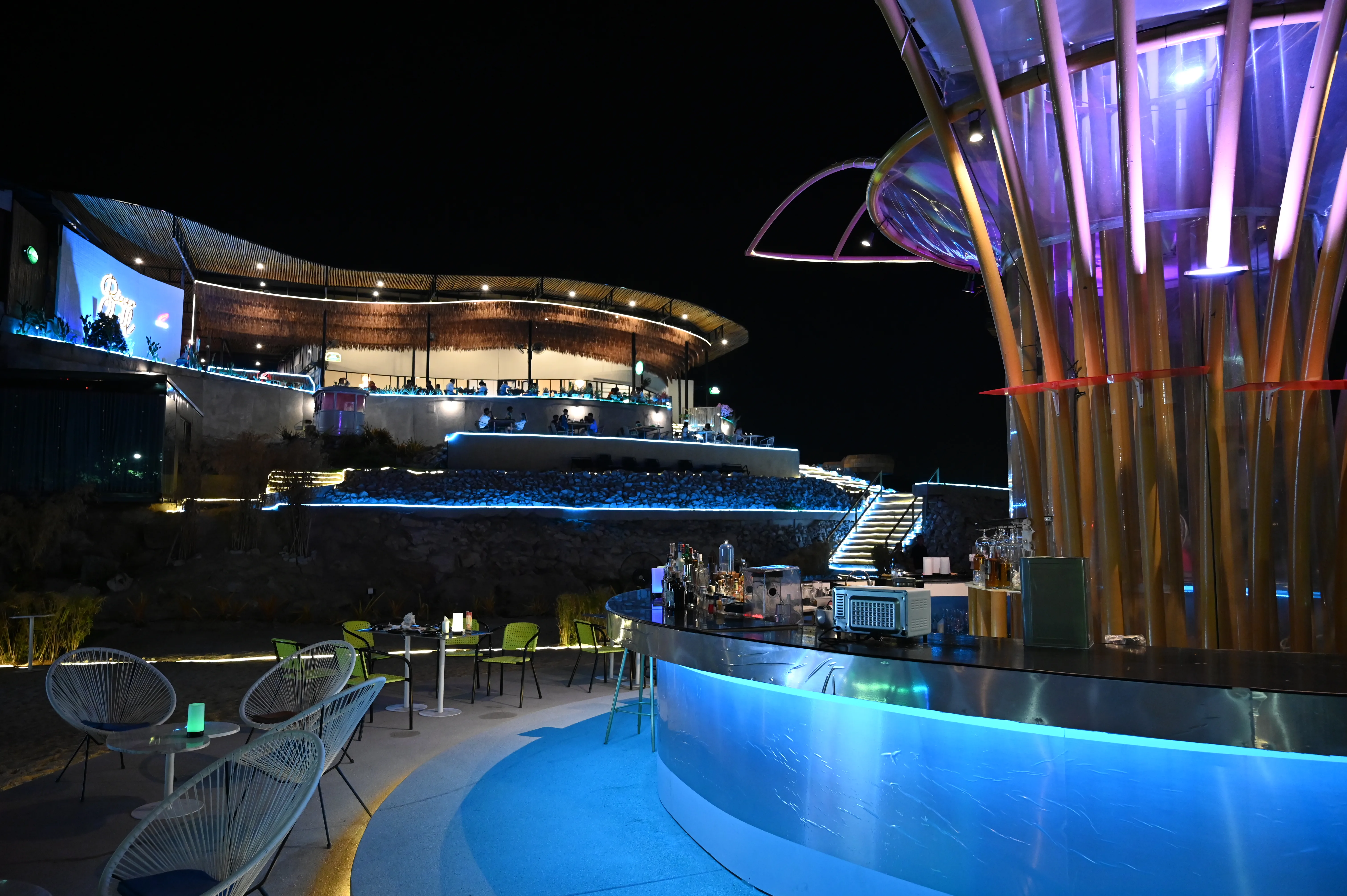 A rooftop bar terrace glowing with lights at night