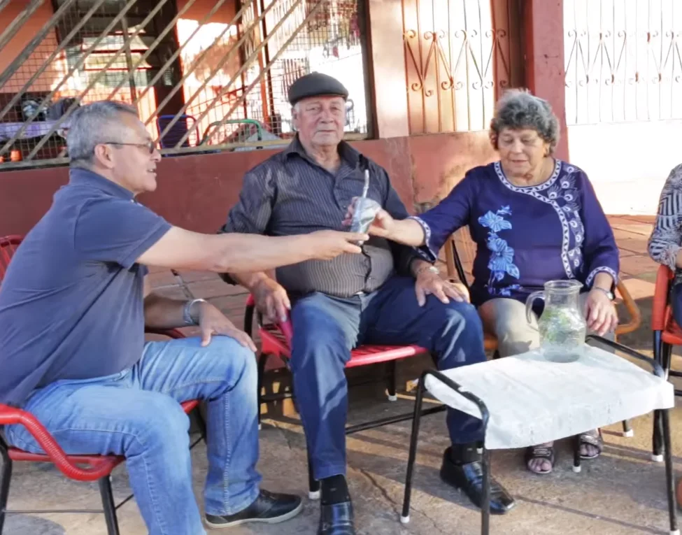 Paraguayans sharing tereré outdoors, one of them passing the guampa