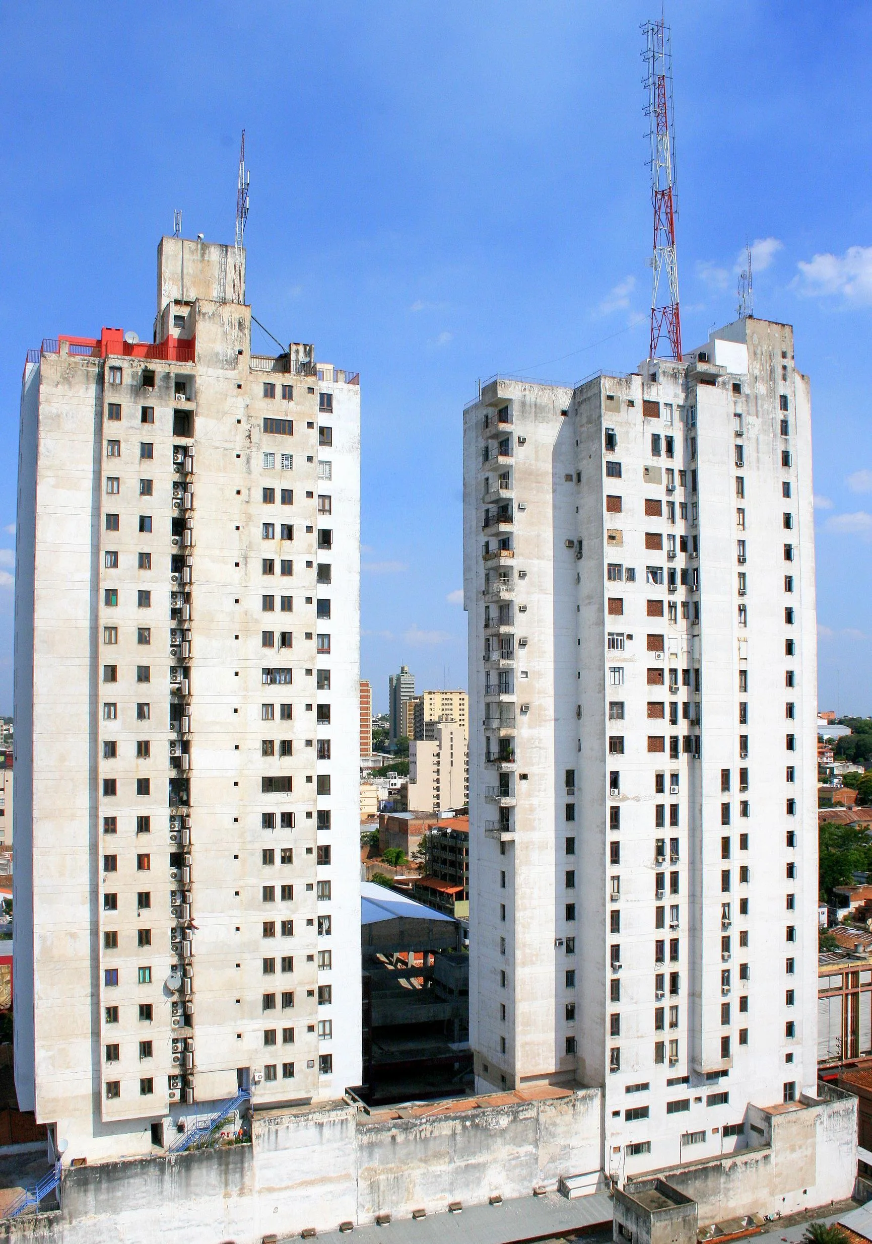 Twin high-rise residential towers in Asunción against a blue sky